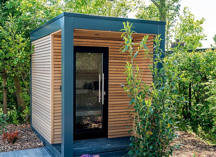 Blue Harrier-Ferienhaus in Den Burg, Texel, inmitten eines ueppigen Gartens.