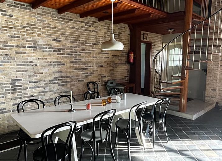 Detail des Ferienhauses in Den Burg, Texel, mit Reetdach und gruener Hecke an der Vorderseite.