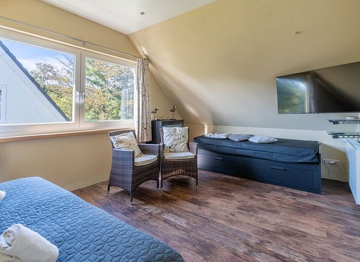 Geraeumige Sitzecke in einem Ferienhaus in Den Burg, Texel, mit moderner Einrichtung und viel Licht.