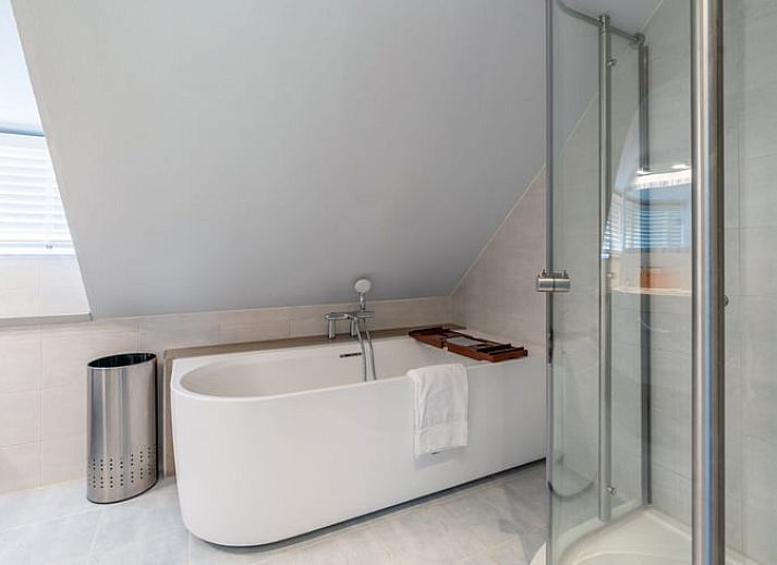 Geraeumige Sitzecke in einem Ferienhaus in Den Burg, Texel, mit moderner Einrichtung und viel Licht.