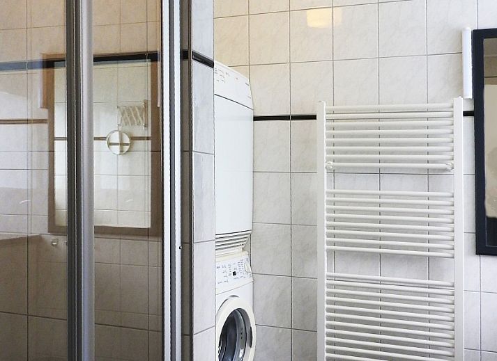 Gezellige woonkamer in familie Smit bungalow Den Burg Texel met comfortabele bank en decoratieve kunst.