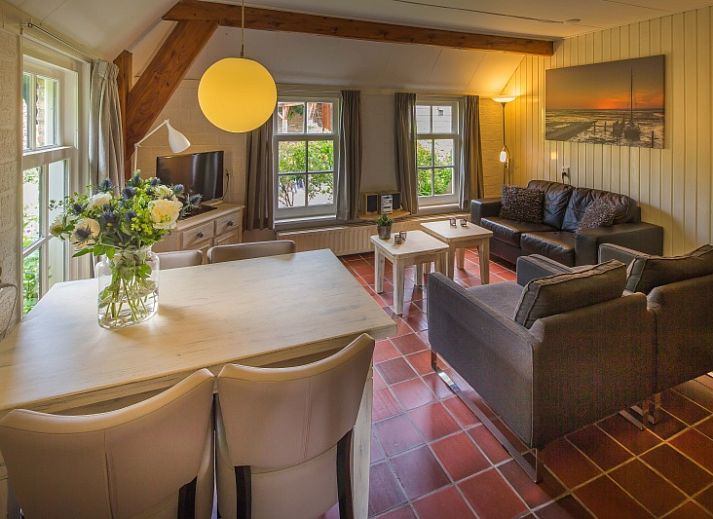 Charming exterior of Apartment De Koolmees in Den Burg, Texel, with traditional roof tiles and green garden.