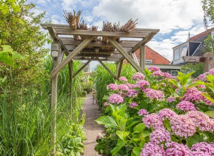 Charming exterior of Apartment De Koolmees in Den Burg, Texel, with traditional roof tiles and green garden.