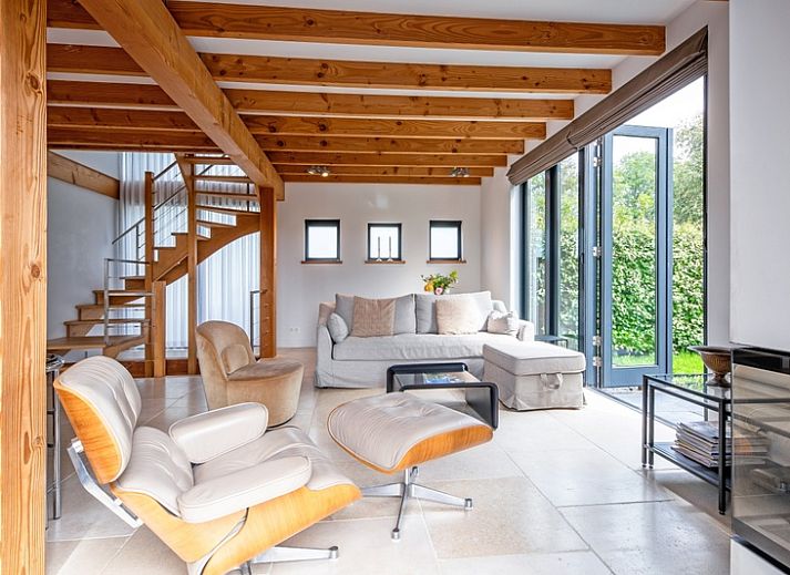 Modern interior of Buitenplaats vacation home in Den Burg Texel with wooden beamed ceiling.