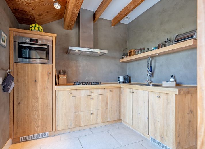 Modern interior of Buitenplaats vacation home in Den Burg Texel with wooden beamed ceiling.