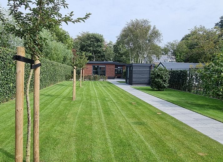 Spacious garden at vacation home Schoonoordsingel 29a in Den Burg, Texel, with beautiful green views.