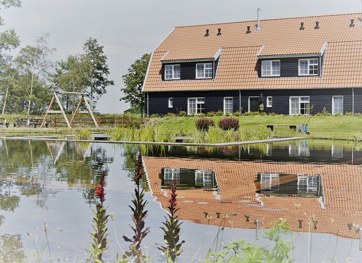 Luchtfoto van Groepsverblijf Nieuw Leven Texel in Den Burg, vakantiehuis op de Waddeneilanden met groene omgeving.