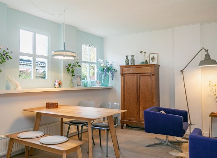 Stadhuisje Texel in Den Burg, charmant vakantiehuis met groene gevel en bloemenrijke omgeving op de Waddeneilanden.