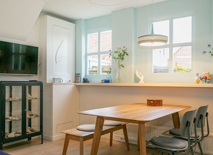 Stadhuisje Texel in Den Burg, charmant vakantiehuis met groene gevel en bloemenrijke omgeving op de Waddeneilanden.