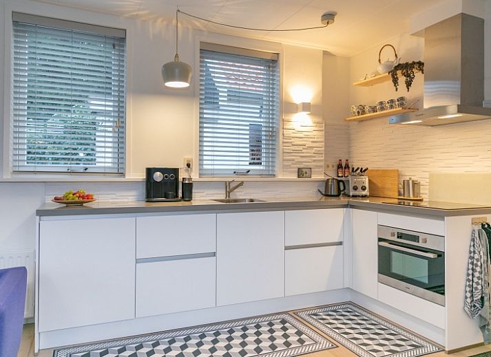 Gezellig terras bij Stadhuisje Texel in Den Burg, vakantiehuis met comfortabele stoelen en groene tuin op de Waddeneilanden.