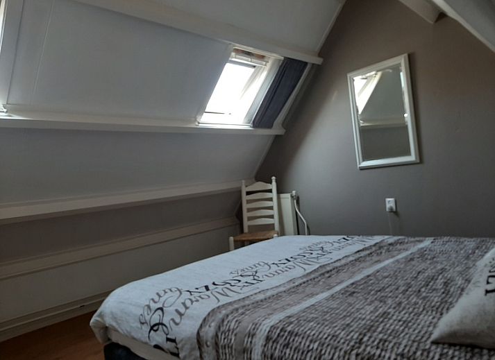 Sonnige Terrasse an De Molen, Ferienhaus in Den Burg, Texel mit Gartenmoebeln und bluehenden Pflanzen.