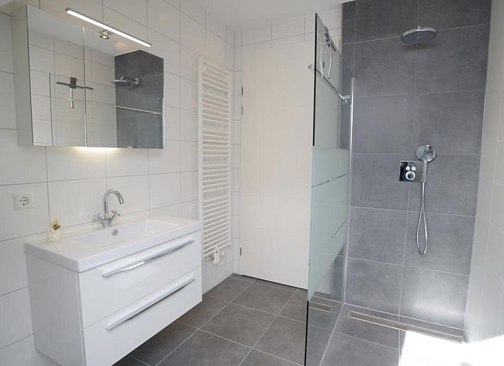 Gezellige leefruimte in Roggesloot vakantiehuis, Texel met ruime banken en decor.