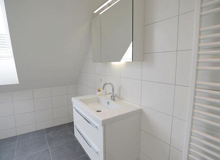 Gezellige leefruimte in Roggesloot vakantiehuis, Texel met ruime banken en decor.