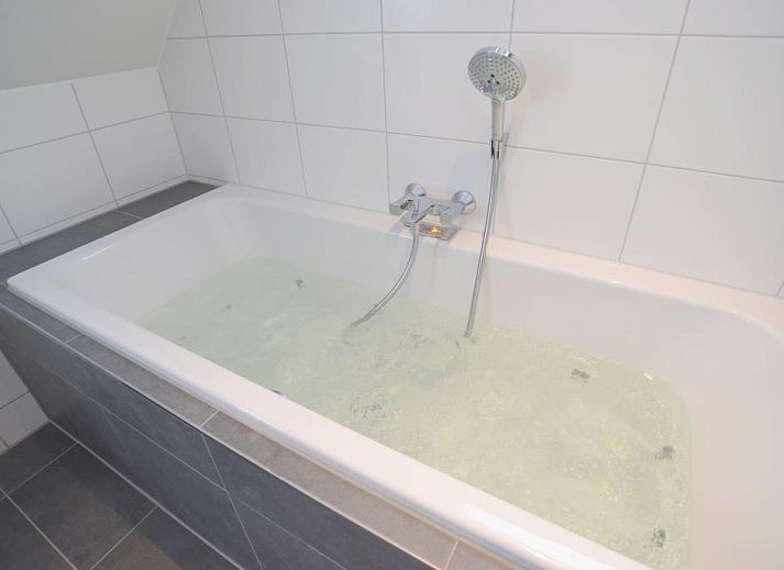 Gezellige leefruimte in Roggesloot vakantiehuis, Texel met ruime banken en decor.