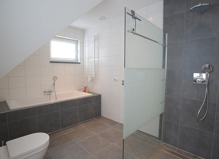 Gezellige leefruimte in Roggesloot vakantiehuis, Texel met ruime banken en decor.