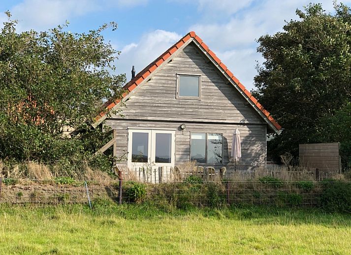 Ferienhaus Duinzicht in Den Burg Texel mit charmanter Holzfassade und gruener Umgebung.