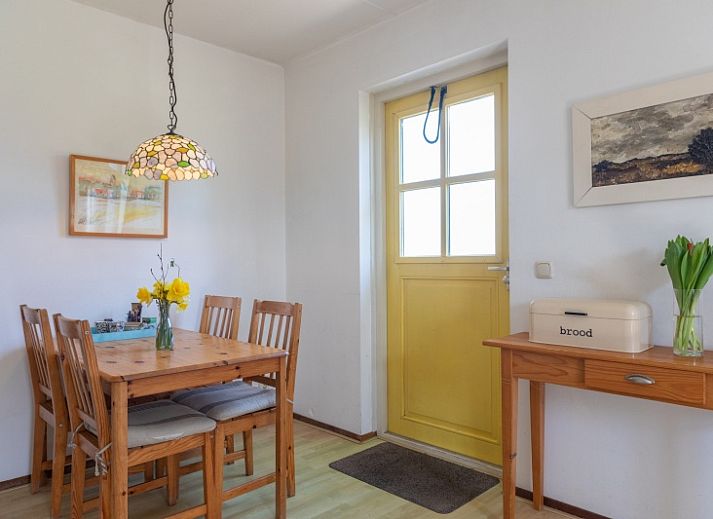 Gemuetliches Wohnzimmer des Ferienhauses Onderhuus in Den Hoorn Texel mit rotem Sofa.