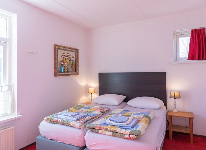 Gemuetliches Wohnzimmer des Ferienhauses Onderhuus in Den Hoorn Texel mit rotem Sofa.