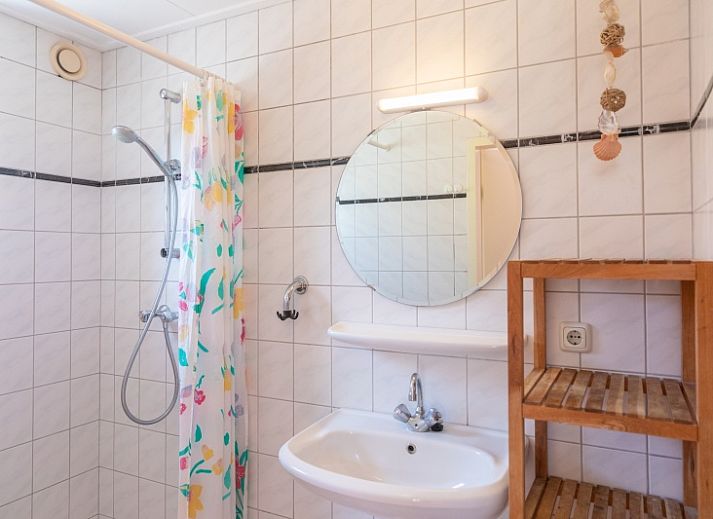 Gemuetliches Wohnzimmer des Ferienhauses Onderhuus in Den Hoorn Texel mit rotem Sofa.