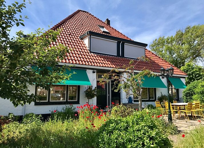 Gemuetliches Schlafzimmer im Doppelstudio 1 in Den Hoorn, Texel, mit Kunst an der Wand und gruenen Akzenten.