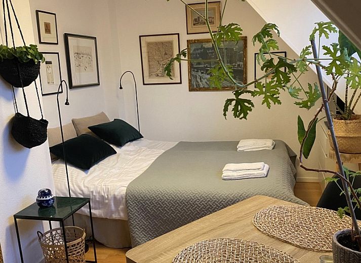 Gemuetliches Schlafzimmer im Doppelstudio 1 in Den Hoorn, Texel, mit Kunst an der Wand und gruenen Akzenten.