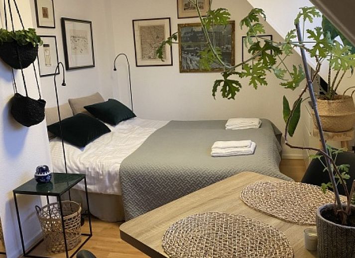 Gemuetliches Schlafzimmer im Doppelstudio 1 in Den Hoorn, Texel, mit Kunst an der Wand und gruenen Akzenten.