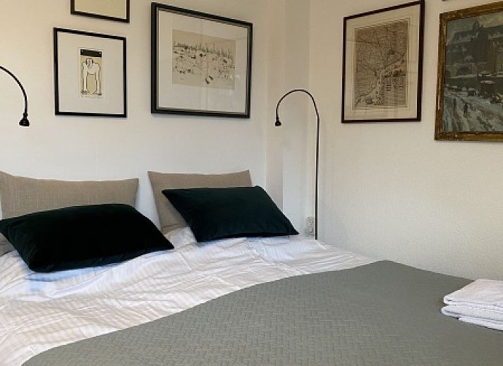 Gemuetliches Schlafzimmer im Doppelstudio 1 in Den Hoorn, Texel, mit Kunst an der Wand und gruenen Akzenten.