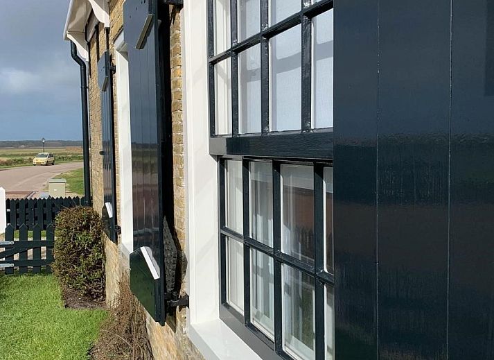 Charmantes Ferienhaus 't Wambuis in Den Hoorn, Texel, mit authentischer Fassade und laendlicher Umgebung.