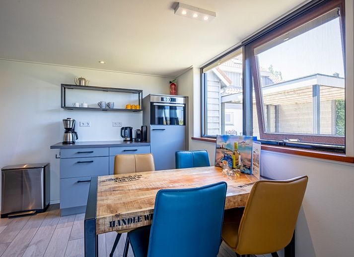 Lichte woonkamer van OpTexel vakantiehuis in Den Hoorn, Texel met comfortabele zitruimte en uitzicht op de natuur.