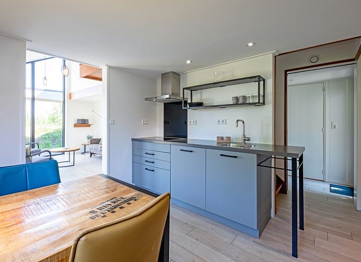 Lichte woonkamer van OpTexel vakantiehuis in Den Hoorn, Texel met comfortabele zitruimte en uitzicht op de natuur.