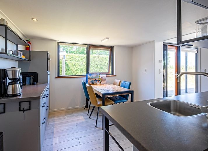 Lichte woonkamer van OpTexel vakantiehuis in Den Hoorn, Texel met comfortabele zitruimte en uitzicht op de natuur.