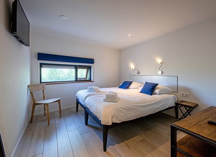 Gezellige binnenruimte van OpTexel in Den Hoorn, Texel met grote ramen en uitzicht op de tuin. Ideaal voor een ontspannen verblijf.