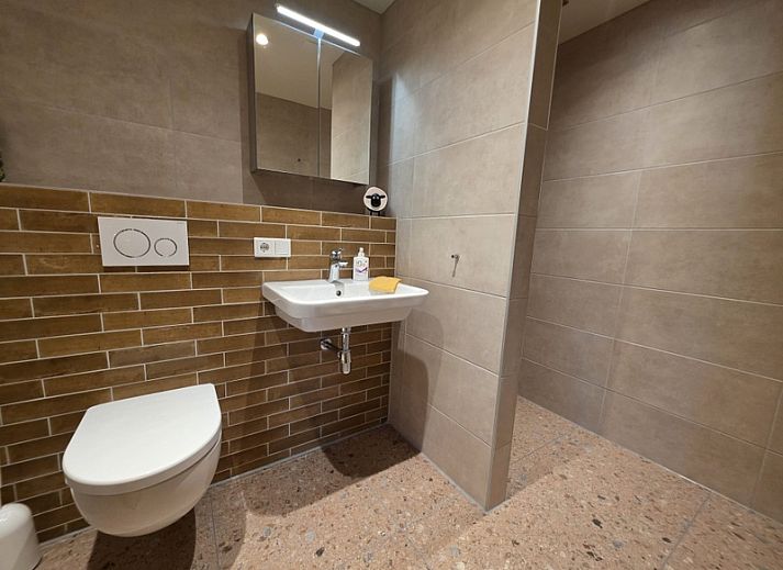 Gemuetliches Wohnzimmer von Apartment Yellow in Den Hoorn, Texel. Komfortables Ferienhaus auf den Watteninseln mit gemuetlicher Sitzecke und rustikalen Moebeln.