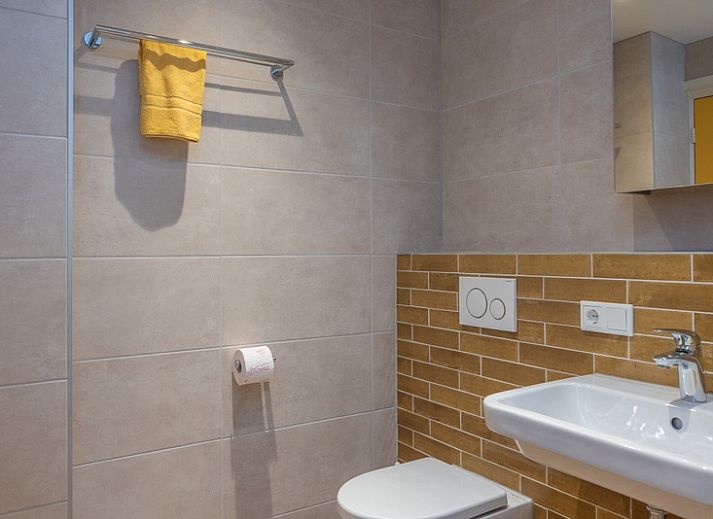 Gemuetliches Wohnzimmer von Apartment Yellow in Den Hoorn, Texel. Komfortables Ferienhaus auf den Watteninseln mit gemuetlicher Sitzecke und rustikalen Moebeln.