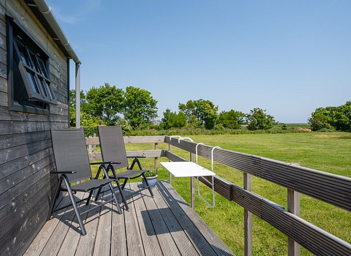 Johanneshoeve - Pipowagen in Den Hoorn, Texel met houten veranda en groene omgeving.