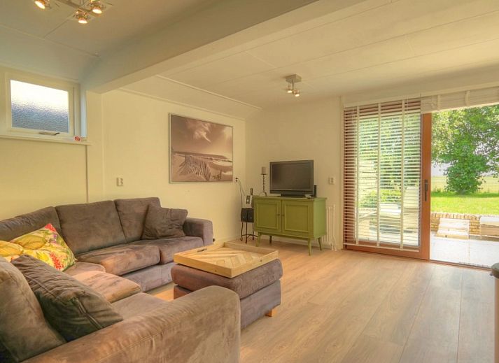 Gezellige woonkamer in Huisje Spyk, vakantiehuis in Den Hoorn Texel met uitzicht op tuin.
