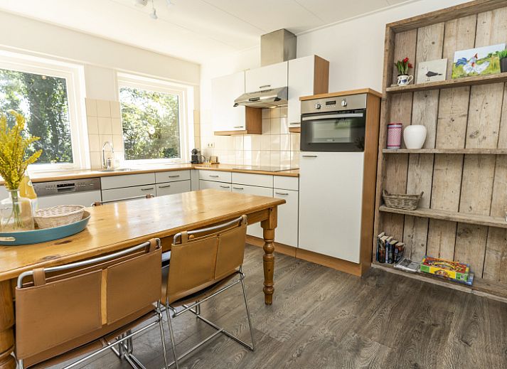 Aussenterrasse des Ferienhauses Sil in Den Hoorn, Texel mit Gartenmoebeln und gruener Umgebung.