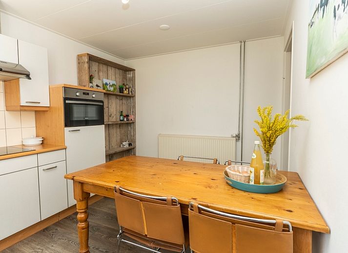 Aussenterrasse des Ferienhauses Sil in Den Hoorn, Texel mit Gartenmoebeln und gruener Umgebung.