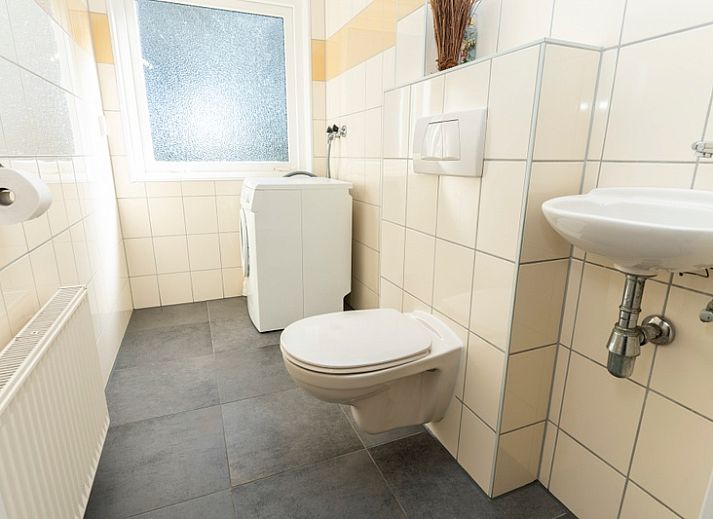 Aussenterrasse des Ferienhauses Sil in Den Hoorn, Texel mit Gartenmoebeln und gruener Umgebung.