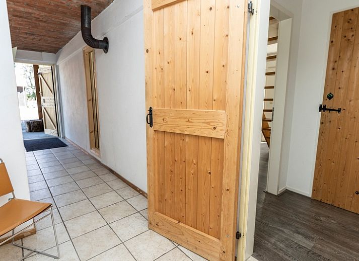 Aussenterrasse des Ferienhauses Sil in Den Hoorn, Texel mit Gartenmoebeln und gruener Umgebung.