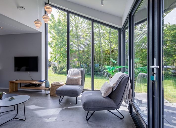 Gezellige woonkamer van TexelZee vakantiehuis op Texel met veel lichtinval.