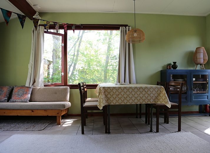 Ferienhaus Vogelsand in Den Hoorn Texel mit gruener Umgebung und Holzfassade.