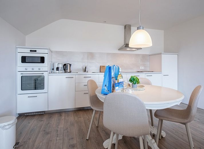 Cozy living room of vacation home Grietje in Den Hoorn, Texel with comfortable seating area and lots of natural light.