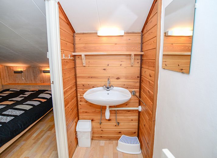 Stijlvolle leeshoek in De Kievit vakantiehuis Den Hoorn Texel met uitzicht op de tuin.