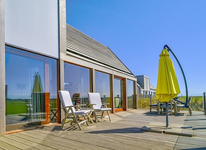Gemuetliches Wohnzimmer von De Waddenhof - Waddenhof-Lodge in Den Hoorn, Texel, mit Blick auf die gruene Umgebung.
