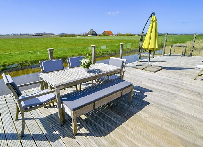 Gemuetliches Wohnzimmer von De Waddenhof - Waddenhof-Lodge in Den Hoorn, Texel, mit Blick auf die gruene Umgebung.