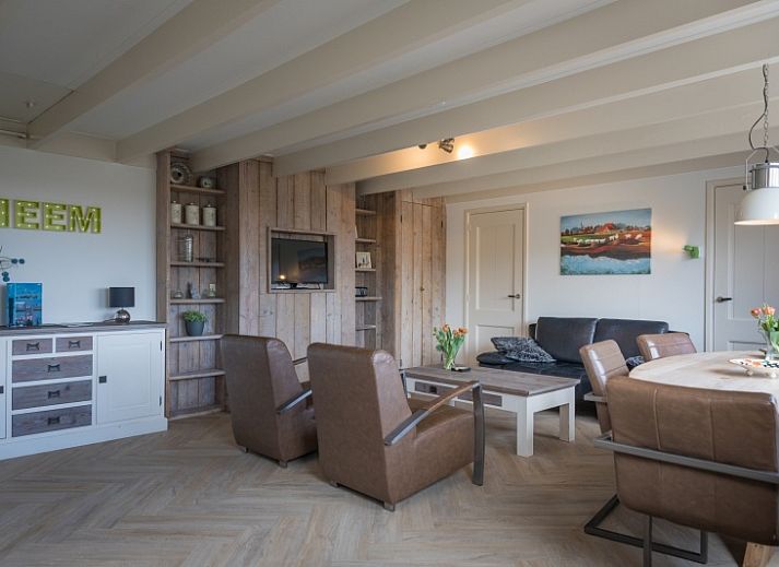 Buitenzicht van Appartement Heem, een charmante vakantiewoning in Den Hoorn, Texel, met traditioneel rieten dak en gezellige veranda.