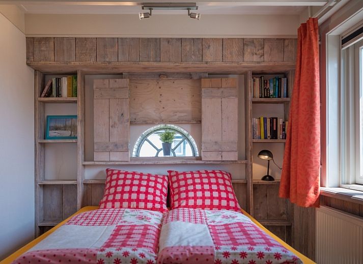 Buitenzicht van Appartement Heem, een charmante vakantiewoning in Den Hoorn, Texel, met traditioneel rieten dak en gezellige veranda.