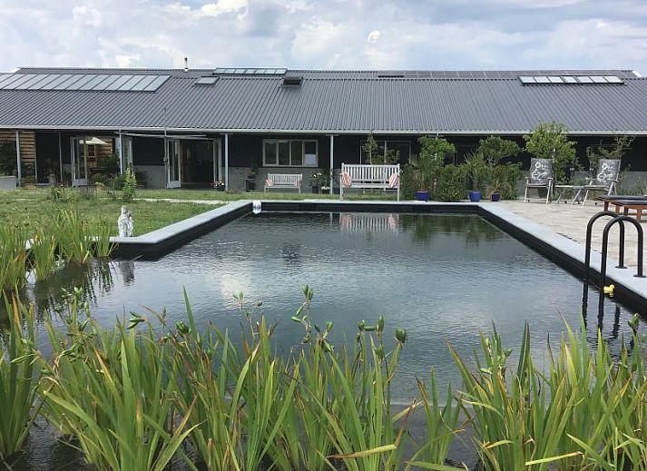 Zithoek met uitzicht in De Borage Texel, Oosterend, biedt comfortabele stoelen en een tafel voor ontspanning en genieten van de omgeving.