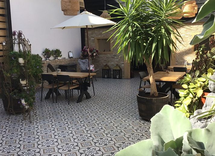 Zithoek met uitzicht in De Borage Texel, Oosterend, biedt comfortabele stoelen en een tafel voor ontspanning en genieten van de omgeving.